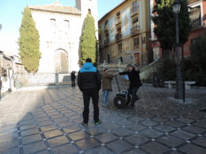 man helps other off Segway scooter